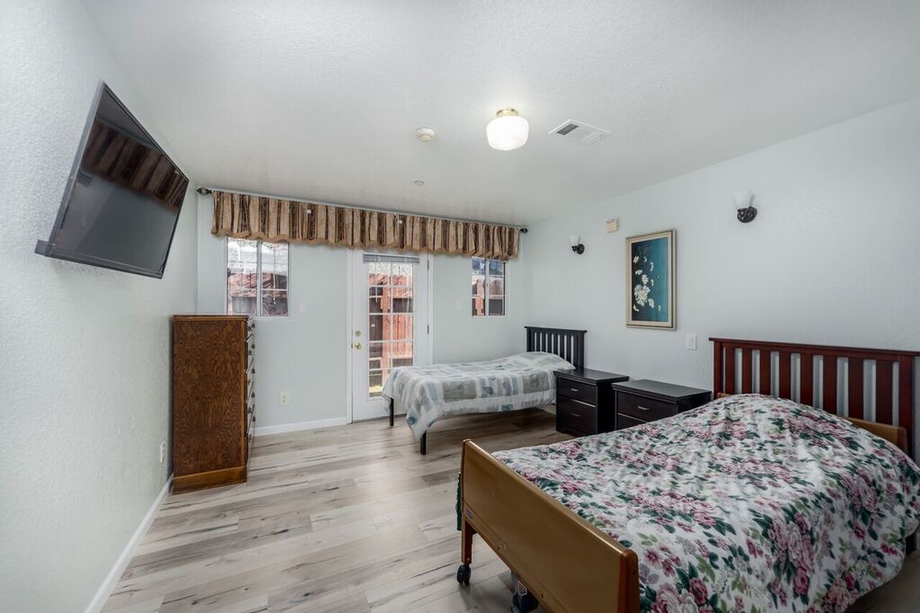 Shared bedroom with two beds, natural light, and a door to the outside